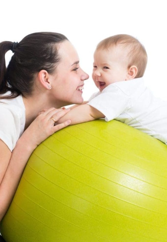 mother and her baby having fun with gymnastic ball