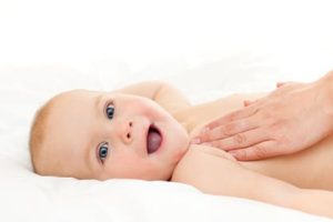 Mother massaging her little baby girl, shallow focus